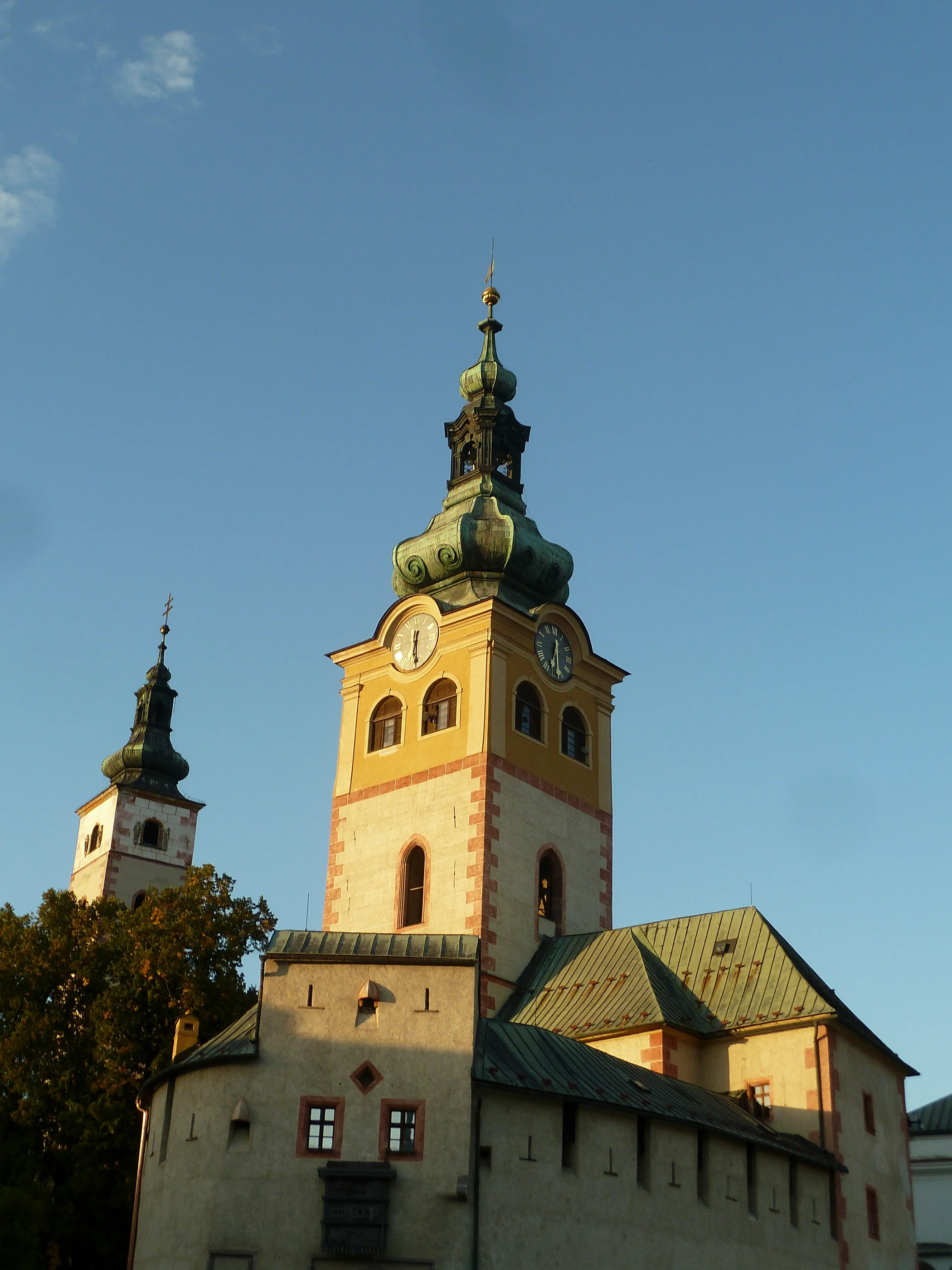 A sunlit tower and stone façade beneath a blue sky
